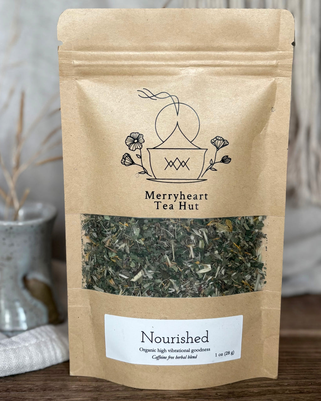 Kraft paper tea bag from Merryheart Tea Hut with tea leaves visible on a neutral background