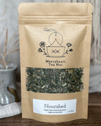 Kraft paper tea bag from Merryheart Tea Hut with tea leaves visible on a neutral background