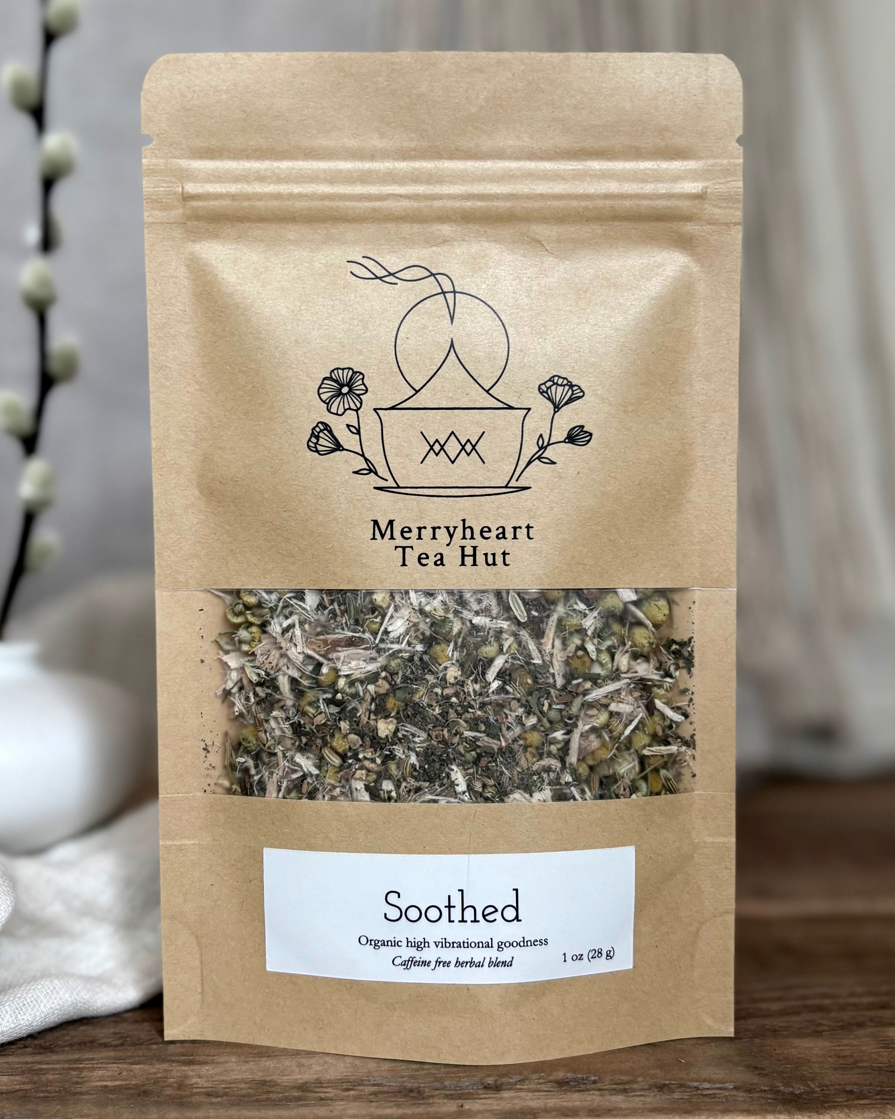 Kraft paper tea bag from Merryheart Tea Hut with visible herbs on a wooden surface.